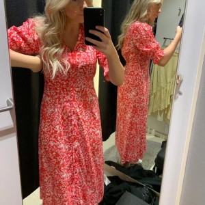 Blommig långklänning  - Lång klänning som är figurnära. En stor favorit i min garderob!! Dessvärre för liten nu.  Röd, rosa, vit 