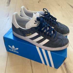 Adidas gazelle 39 1/3 - Blåa gazelle från adidas i använt skick. Något smutsiga längst ner men det går nog att tvätta bort! Annars i fint skick! 
