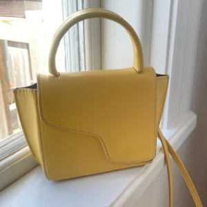 Gul ATP atelier väska  - Säljer denna super fina väskan, det finns skador över hela därav priset. Utöver det en jätte fin väska och skadorna är inte något som drar ner väskan i helhet. Finns en till bild på baksidan som ej fick plats här😊