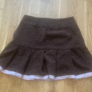 Kjol med spets - Jätte söt brun kjol med rosa spets detaljer som tyvärr inte kommer till användning. Storlek xs-s
