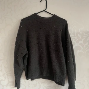 Stickad tröja med pärlor - En mycket fin mörkgrå stickad tröja med pärlor på och har använt fåtal gånger💕