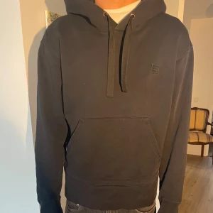 Svart hoodie med ficka - Säljer en svart hoodie i storlek s. Den är superbekväm och har en stor ficka på magen samt en justerbar huva med snören. Perfekt för höst och vinter! 🖤