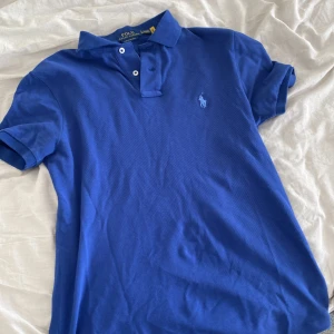 Ralph lauren pike blå - Pikén är i storlek S i herrstorlek och skicket är nästan som ny. Den har används ett fåtal gånger under denna sommar men har inga tecken på skador.
