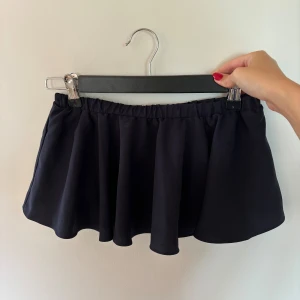 Flowy Bandeu topp i marinblått - Helt oanvänd! Har ett underlinne som fungerar som en BH, ligger bekvämt mot huden! Från Linn Ahlborgs kollektion med NA-KD.