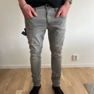 Säljer ett par grå Replay Anbass jeans i storlek 31. De är i bra skick. Jeansen har en klassisk femficksdesign och är gjorda i ett bekvämt material som sitter bra hela dagen.