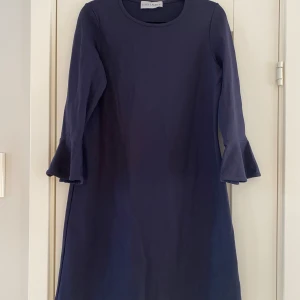Marinblå klänning från Estee Lauder i strl S - Marinblå klänning från Estee Lauder i strl S  Sparsamt använd men tyvärr finns det några ljusare fläckar på framsidan. I övrigt i bra begagnat skick.  Mått Över bröstet: ca 47 cm Längd från axeln och ner: ca 90 cm  62% rayon, 32% nylon och 6% spandex