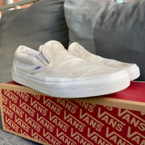 Vans slip on white 42,5 - Vita slipons som är mer i färgen of white.  Skitiga men väldigt bra skick då dom knappt är använda.  Kommer i originalkartongen.   