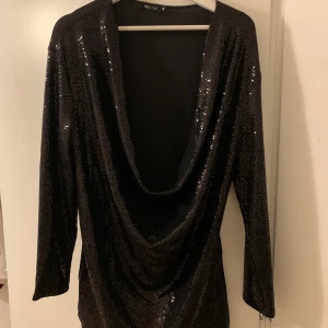 Paljettklänning från Nelly - Svart kort klänning från Nelly med paljetter. Har djup urringning. Perfekt till nyår. Endast använd en gång. Passar storlek S-M.  Köparen står för frakt 💕