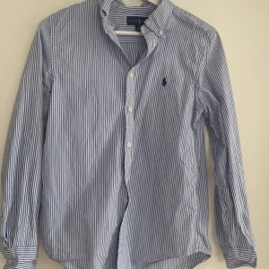 Ralph Lauren skjorta  - Säljer denna använda Ralph lauren skjortan. Skjortan är i gott skick och i storleken 16 (XS). Ny pris är ca 899 kr. Hör av er vid funderingar!