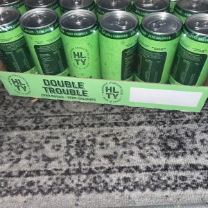 HLTY Double Trouble - Ett flak HLTY Double Trouble, en lätt kolsyrad dryck med smak av gurka och fläder🍋‍🟩🥒. Den är sockerfri och har tillsatt koffein och massa vitaminer. Burkarna är gröna och innehåller 330 ml vardera. 23 burkar kvar.
