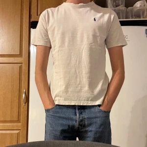 Polo Ralph lauren t-shirt - Vit polo Ralph lauren t-shirt  Storlek 160/14-16 sitter som xs/s killen på bilden är 182 cm. Om du har funderingar kring t-shirten så är det bara att höra av dig. Priset kan diskuteras vid snabb affär👍