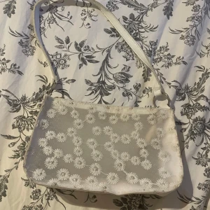 Fin blommig axelväska  - En fin blommig genomskinlig axelväska med små ditaljer