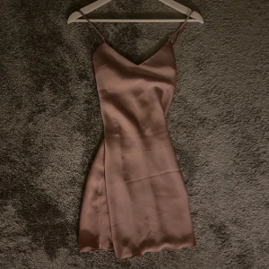 Rosa sidenklänning🎀 - Kort klänning, perfekt till fester😍 korsade band i ryggen. Spets & v-ringad rygg. Spetsen ser typ beige ut på bilden, d är i samma färg som klänningen i verkligheten. Endast använt en gång, nyskick🥰