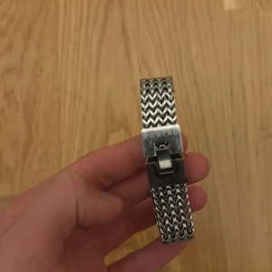 Silver Armband EDBLAD - Säljer ett stilrent och snyggt klockarmband i silverfärg från märket EDBLAD. Armbandet har ett flätat mönster som ger en modern och elegant look. Perfekt för att uppgradera din klocka med en ny stil! PRIS  KAN DISKUTERAS, ORGINAL PRIS 599kr 
