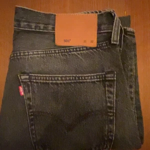 Klassiska Levis 501 - Säljer mina Svart/gråa Levis 501 som är i ett väldigt bra skick, 9/10. Strl på dessa är W31L32. Passformen är regular. Nypris runt 1200, säljer dessa för endast 300 kr. Skriv vid funderingar! 