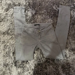 Grå jeans från Tally Weijl - Säljer ett par snygga grå jeans från Tally Weijl. De har en klassisk femficksdesign och är i storlek 32. Perfekta för vardagsbruk och kan enkelt matchas med olika toppar. De är i bra skick och redo för en ny ägare!