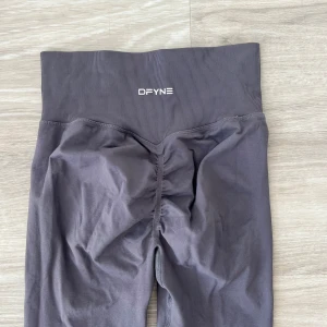 DFYNE träningstights - Träningstights från DFYNE, sitter jättefint, storlek S, långa i benen, jag är 173 och de är perfekta på mig! Nypris är cirka 650kr, använda max 2 gånger!