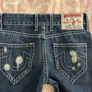 True Religion Jeans W28 - Ett par supersnygga true religion jeans som är köpta från plick för 950kr så säljer de för 800kr. Storleken är W28 L32! Säljer de då de var för små på mig ☺️Priset är diskuterbart, skriv om du har några funderingar eller för fler bilder 🩷 