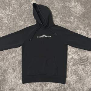 Säljer en stilren svart hoodie från Peak Performance. Den har en klassisk design med en känguruficka framtill och justerbar huva med dragsko. Perfekt för både vardag och träning!