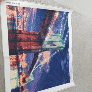Diamond painting av bro - Säljer en färgglad diamond painting med motiv av en bro i kvällsbelysning. Tavlan är 50 x 40 cm stor och har en vacker mix av blå, röd och grön nyanser. Perfekt för den som gillar att ha fina tavlor i hemmet eller kontoret. Säljer 2 stycken