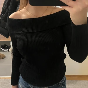 Svart offshoulder tröja - Snygg svart offshoulder tröja i ribbat material och är i storlek S. Använd ett fåtal gånger. 