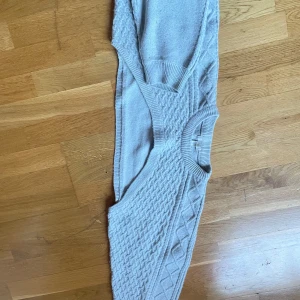 Beige stickad tröja - Säljer en mysig beige stickad tröja med ett snyggt flätmönster. Tröjan har långa ärmar och ribbade kanter vid hals och ärmslut. Perfekt för kyliga dagar!