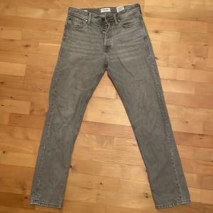 Grå jeans från Jack & Jones - Säljer ett par grå jeans från Jack & Jones. De har en klassisk femficksdesign och är tillverkade i bomull. Perfekta för en avslappnad stil. De är i jätte fint skick. Storlek: 28W 32L