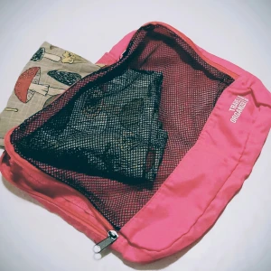 Rosa Travel Organizer - Praktisk rosa travel organizer med nätficka och dragkedja. Perfekt för att hålla ordning på dina saker under resan. Medium storlek med bärhandtag.