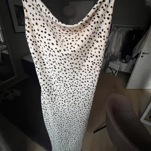 Mönstrad klänning - Snygg långklänning med ett prickigt mönster i svart och kräm vit. Klänningen har justerbara band så passar alla💕💗 endast använd en gång (på bilden) så är i väldigt gott skick🩷