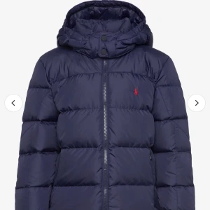 Mörkblå dunjacka från Polo Ralph Lauren - Säljer en snygg mörkblå dunjacka från Polo Ralph Lauren. Perfekt julklapp! Barnstorlek xl, 18-20 år men jag har använt den som i vanliga fall har s. Köptes förra vintern så i bra skick, sista bilden visar att ”hängaren” gått sönder men tror de går att laga enkelt om man vill (den går frf att hänga upp i den andra ”hängaren”) priset går att diskutera😊