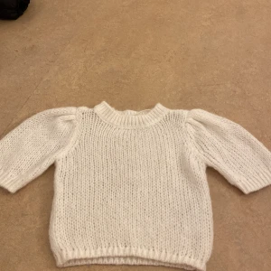Vit stickad tröja - Mysig vit stickad tröja med rund hals och puffiga ärmar. Perfekt för kyliga dagar och ger en stilren look. Passar bra till både jeans och kjol. Helt ny och använt den bara 1 gång, från Vera Moda. I storlek s fast det passar xs också.