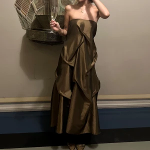 Brun axelbandslös klänning/ kjol  - Elegant brun axelbandslös klänning med draperad design. Perfekt för festliga tillfällen. Kan bäras som långkjol med släp eller klänning !! 