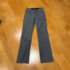 Grå bootcut jeans - Snygga grå bootcut jeans med låg midja och fransade kanter. Perfekta för en avslappnad stil. Filippa K stolek 27/34