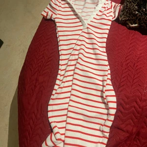 Vit och röd randig klänning från H&M - Säljer en söt vit och röd randig klänning från H&M. Klänningen har en v-ringad hals och korta ärmar, perfekt för en avslappnad stil. Materialet är mjukt och bekvämt. Till julen 😍😍