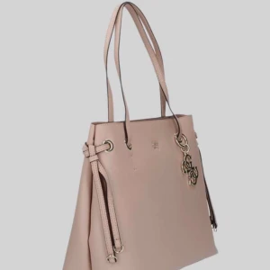 GUESS SHOPPER BAG  - Snygg beige axelväska med eleganta detaljer. Väskan har en praktisk dragkedja på baksidan och dekorativa knytband på sidorna. Perfekt för att bära dina dagliga nödvändigheter med stil.
