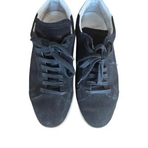 Svarta sneakers från Saint Laurent - Snygga svarta sneakers från Saint Laurent med klassisk snörning och stilren design. Skorna har en vit sula vilket ger en lyxig känsla. Perfekta för en trendig och avslappnad look. Skick 9/10