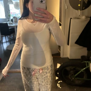 Vit/Genomskinlig långärmad tröja  - Säljer en stilren vit ribbad topp från H&M. Den är långärmad och har en rund halsringning. Perfekt för lager-på-lager eller som den är. Passar till många olika stilar och tillfällen. Linnet som jag har under ingår inte. 