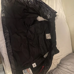 Svart dunväst från Moncler - Svart mocler väst. Den är storlek M och är bekväm och passar bra jag är 178 o passar bra. Jag har använt den en halv sommar 