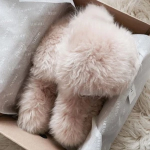 INUIKII Cosy Slipper Powder🌸 - Mysiga och fluffiga tofflor i beige färg. Perfekta för att hålla fötterna varma och bekväma hemma. De har en mjuk och lurvig yta som ger en lyxig känsla.