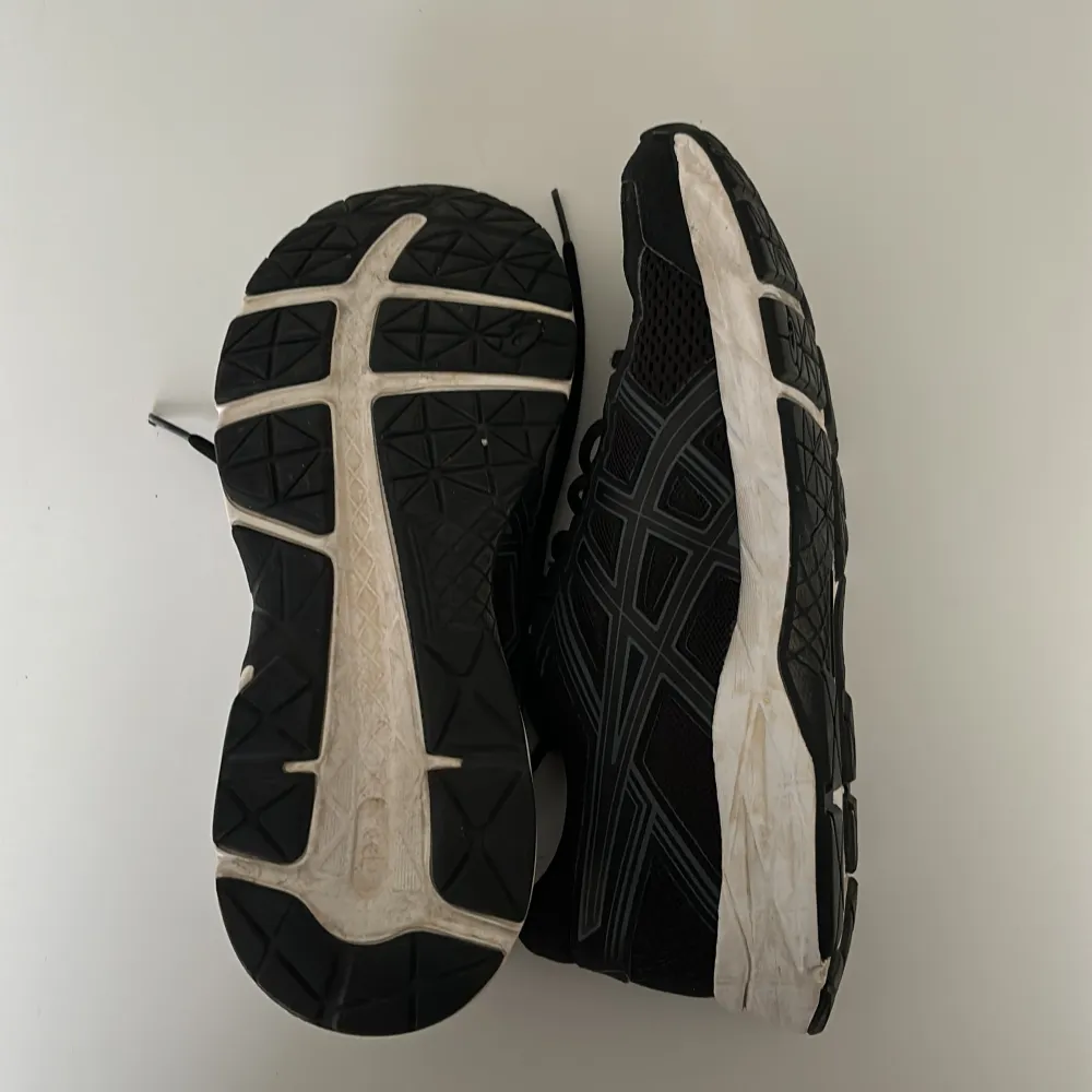 Säljer ett par svarta Asics sneakers i bra skick. De har en snygg design med snörning och en vit sula som ger bra grepp. Perfekta för träning eller vardagsbruk.. Kengät.