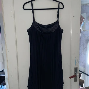 Svart klänning från Zay - Säljer en elegant svart klänning från Zay i storlek S. Klänningen är ärmlös med smala axelband och har en stilren design. Perfekt för festliga tillfällen eller en utekväll. Materialet känns mjukt och lyxigt.