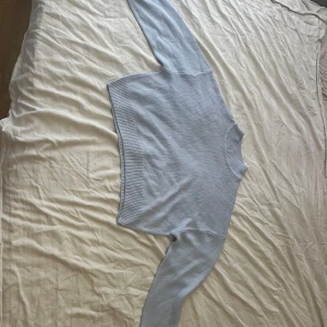 Blå stickad tröja  - En ljusblå stickad tröja.