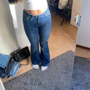 Säljer dessa blåa lågmidjade bootcut  jeansen från lager 157 helt oanvända i storlek W27 L32, passar både xs och s:)