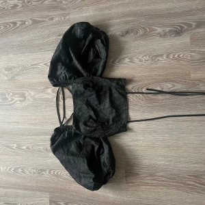 Topp med öppen rygg - Fin topp med öppen rygg och ballongarmar från na-kd. Aldrig använd bara testad.
