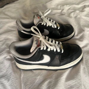 Nike Air Force sneakers - Säljer ett par klassiska svarta Nike Air Force sneakers med vit sula och vita detaljer. Skorna har snörning och är i svart skinnmaterial. De är köpta från zalando och är i bra skick. Priset är diskuterbart💕