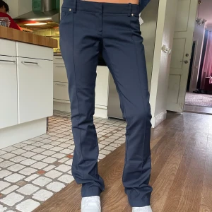 Låga bootcut kostymbyxor - Säljer de här superfina lågmidjade bootcut kostymbyxor i nyskick! 40cm över midjan och 106cm i längd. De är i mörkblå och är stretchiga så väldigt sköna att ha på sig.