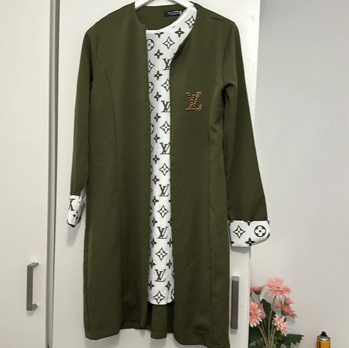 Olivgrön lång jacka med mönstrad insida