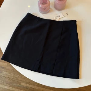 Söt kort svart kjol med slits  - Jätte fin svart kort kjol med slits och dragkedja som aldrig är använd (+med prislapp kvar) 🖤 Skulle säga att den är liten i storleken men skicka ett meddelande om du vill ha mått☺️ 