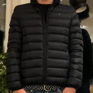 Tommy Hilfiger Essential Light Down Jacka - Säljer denna Marinblå Tommy Hilfiger Jackan som är perfekt för hösten och vintern! köpte den för 1800kr och använd 2 gånger för den har alltid varit för liten för mig. Det är storlek 176CM/16 ÅR  som motsvarar XS, skicket är 10/10! (Inte fast pris)