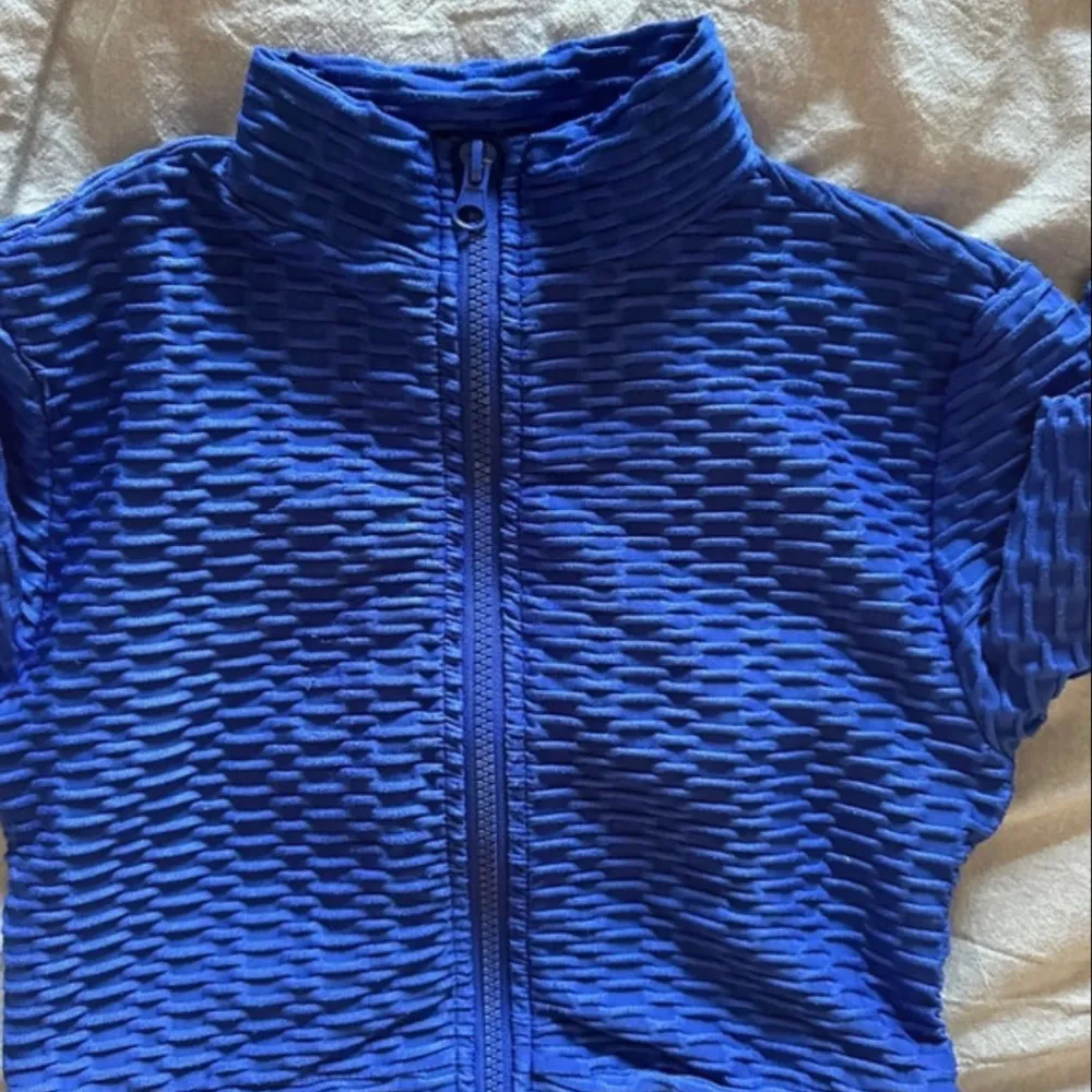 Nice top for training - nice blue colour and textured material making it unique. Very pretty in person . Sportswear.